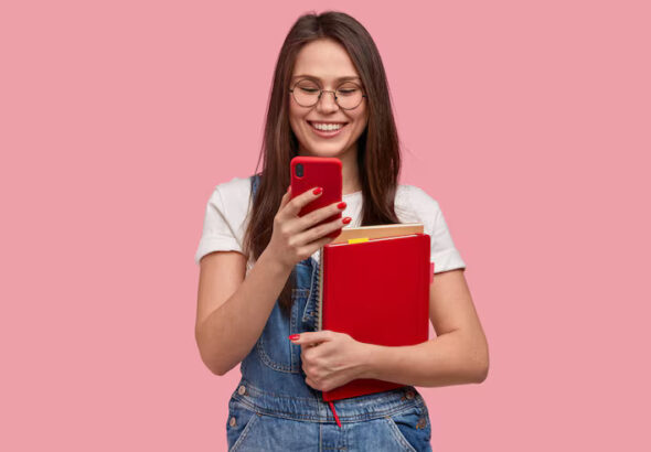 mujer-bonita-morena-sostiene-telefono-movil-envia-mensaje-texto-feliz-leer-comentarios-debajo-publicacion-sostiene-libro-texto_273609-25136 (1)