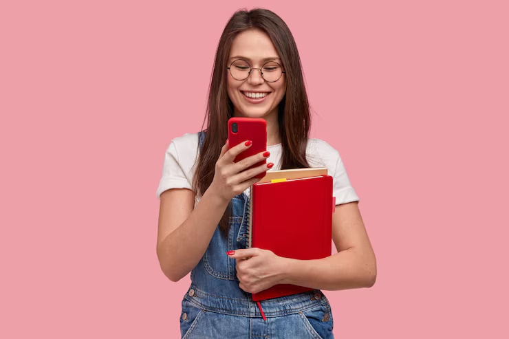 mujer-bonita-morena-sostiene-telefono-movil-envia-mensaje-texto-feliz-leer-comentarios-debajo-publicacion-sostiene-libro-texto_273609-25136 (1)